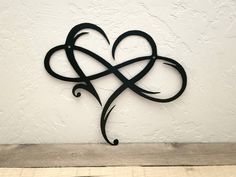 a metal heart on the side of a wall with an intricate design in the middle