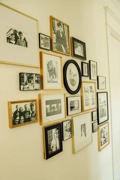 a wall with many framed pictures on it