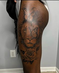 a man with a lion tattoo on his thigh and leg, holding onto a rose