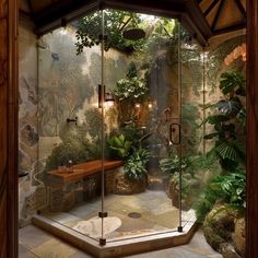 a bathroom with glass walls and plants in the shower area, surrounded by stone flooring