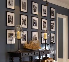 a dining room with pictures on the wall and candles in vases sitting on a table