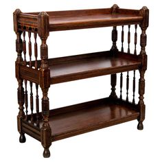 three tiered wooden shelf with spindles on the top and bottom, against a white background