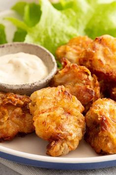 chicken wings with ranch dressing and lettuce on a white plate, ready to be eaten