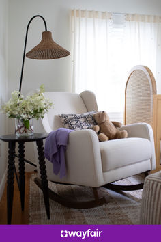 a teddy bear sitting on a rocking chair in a living room