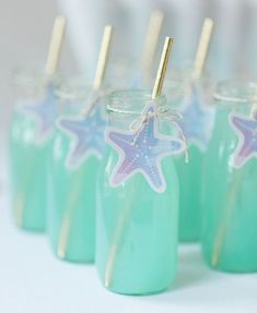 there are some little jars with straws in them and starfish decorations on the top