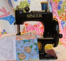 a sewing machine sitting on top of a quilt