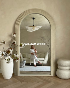 a woman sitting on a couch in front of a mirror with the words william wood