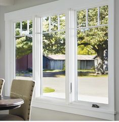 a dining room table and chairs with large windows