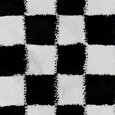 a black and white checkered rug is shown in close up, it looks like the fabric has been cut into squares