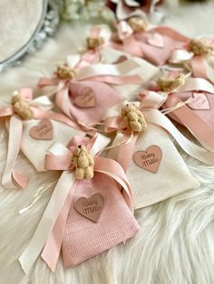 several small teddy bears are tied together with pink ribbons and tags that read, love you so much