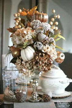 a vase filled with flowers sitting on top of a table next to other decorations and dishes