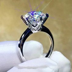 a close up of a diamond ring on top of a white cloth with snow around it