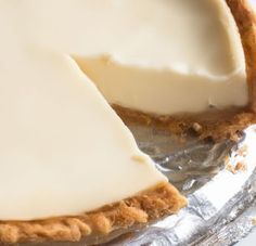 there is a pie that has been cut in half and sitting on tin foil with one slice missing