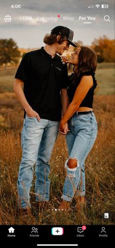 a man and woman standing next to each other in a field with the caption on their phone