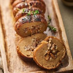 sliced meatloaf with mushrooms and herbs on a wooden cutting board, ready to be eaten