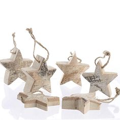 three wooden stars are hanging from rope on a white background, one has an ornament in the shape of a star