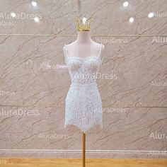 a mannequin wearing a white dress with a gold crown on top