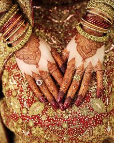 the hands and feet of a woman wearing henna