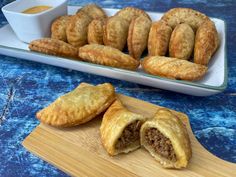 pastries on a cutting board with dipping sauce