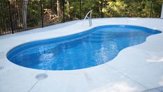 an empty swimming pool in the middle of a yard