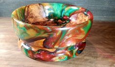 a colorful glass bowl sitting on top of a wooden table