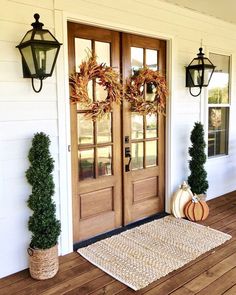 two wreaths on the front door of a house