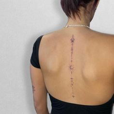 the back of a woman's neck with tattoos on her upper and lower back