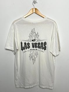 This tee shirt has faint marks on the front side and one on the back side near the graphic. It also has a small mark on the right arm. (Please see photos for flaws) Measurements pit to pit:  21 inches  Top to bottom: 28 inches Flame Graphic, Las Vegas Usa, Vintage Y2k, Tee Shirt, Las Vegas, Graphic Tees, Tee Shirts, Adult Outfits, Tops & Tees