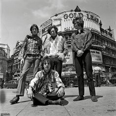 the rolling stones posing for a photo in front of an old building