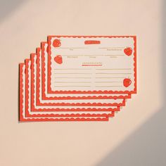 four red and white papers with hearts on them sitting next to each other in front of a wall