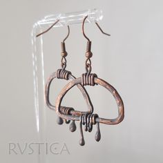 These handcrafted earrings showcase the raw beauty of metalworking. The hammering process leaves behind a unique, textured surface that adds incredible depth and character. The semi-rounded shape offers a soft, organic appeal, while the dangling copper drops lend an eye-catching movement. The dark patina enhances the vintage-inspired look, creating pieces that feel timeless and full of stories untold. Ideal for those drawn to one-of-a-kind artisanal jewelry with a hint of ruggedness and plenty o Oxidized Adjustable Dangle Earrings, Adjustable Oxidized Dangle Earrings, Hand Forged Copper Dangle Hoop Earrings, Hand Forged Copper Hoop Earrings With Dangle, Bronze Metal Dangle Teardrop Earrings, Bronze Metal Teardrop Dangle Earrings, Metal Earrings With Oxidized Finish, Artisan Soldered Teardrop Earrings, Artisan Hammered Dangle Hoop Earrings