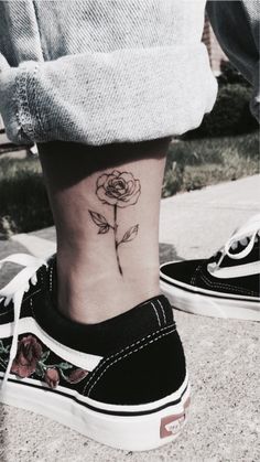 a woman's foot with a rose tattoo on it