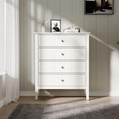 a white chest of drawers sitting on top of a wooden floor