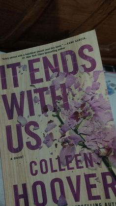 the book it ends with us by collien hoover is sitting on a bed