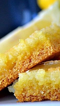 two pieces of cake sitting on top of a white plate next to lemon wedges