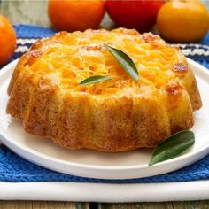 a cake on a plate with oranges in the background