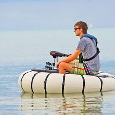 a man sitting on top of an inflatable boat with a bike attached to it