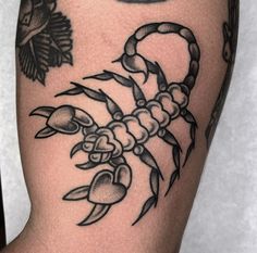 a black and white scorpion tattoo on the arm