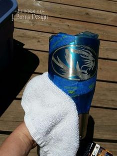 a person with a towel wrapped around their hand and a beer can in the other hand