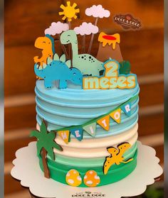 a birthday cake decorated with dinosaurs and bunting banner for two messes party