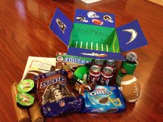 an open box filled with sports snacks on top of a wooden floor next to other items