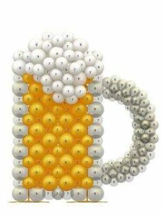 a beer mug made out of balloons is shown in the shape of a balloon with gold and silver balls