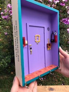 a hand holding up a purple box with two doors