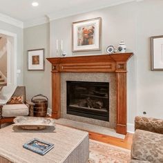 a living room with a fire place and pictures on the wall