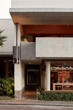 an outside view of a restaurant with plants on the side