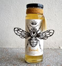 a jar filled with honey sitting on top of a counter next to a white wall