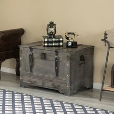 an old trunk sitting on top of a wooden table next to a chair and clock