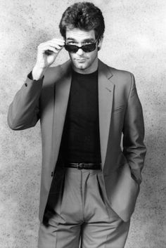 a man in a suit and sunglasses poses for a black - and - white photo