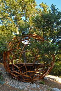 a wooden sculpture in the middle of a forest