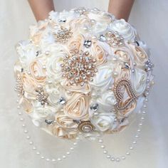 a bridal bouquet with pearls and brooches on the bride's arm